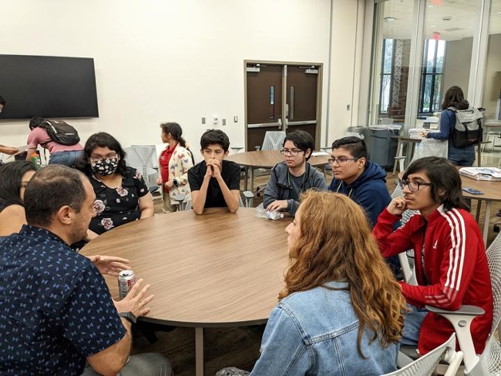 Dean's Excellence Group having a meeting and discussion around a table